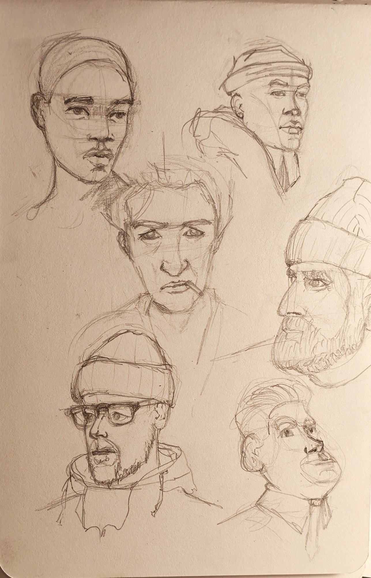 Sketchbook page of quick pencil heads at different angles, construction shapes left visible