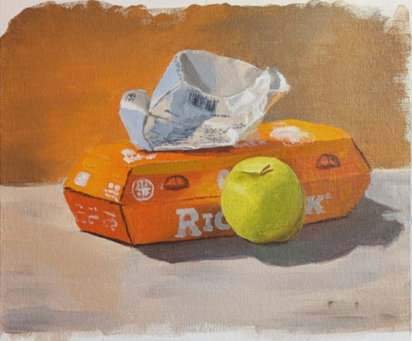 Acrylic still life of a green apple beside an orange cardboard box with a crumpled paper bag on top, on a pale surface against an ochre wall